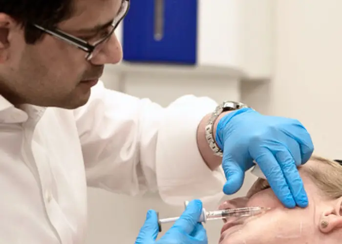 Dr Q treating a patient inside Luxe Skin clinic, Ingram Street, Glasgow